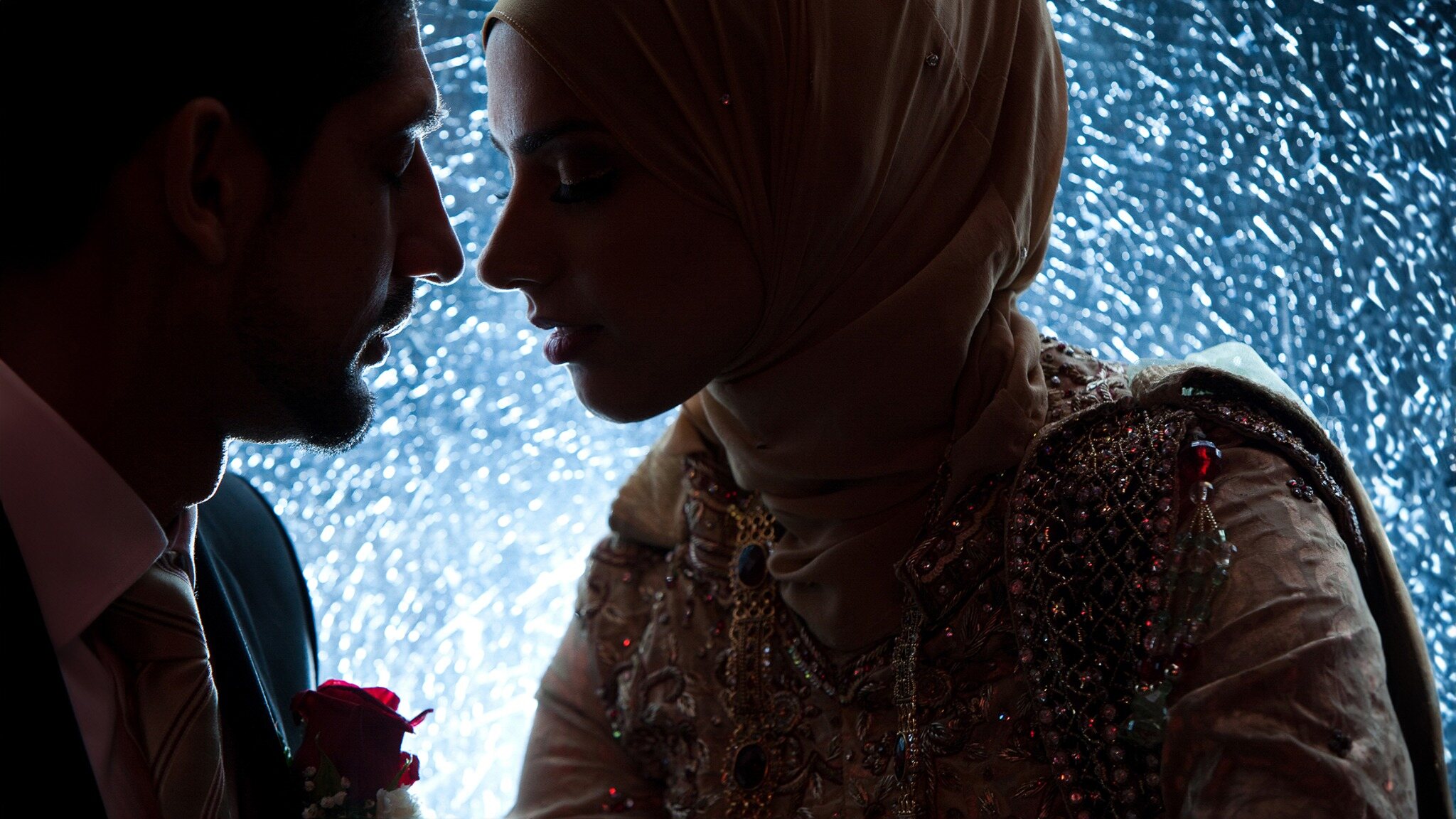 Couple sharing an intimate wedding portrait beneath blue evening lighting